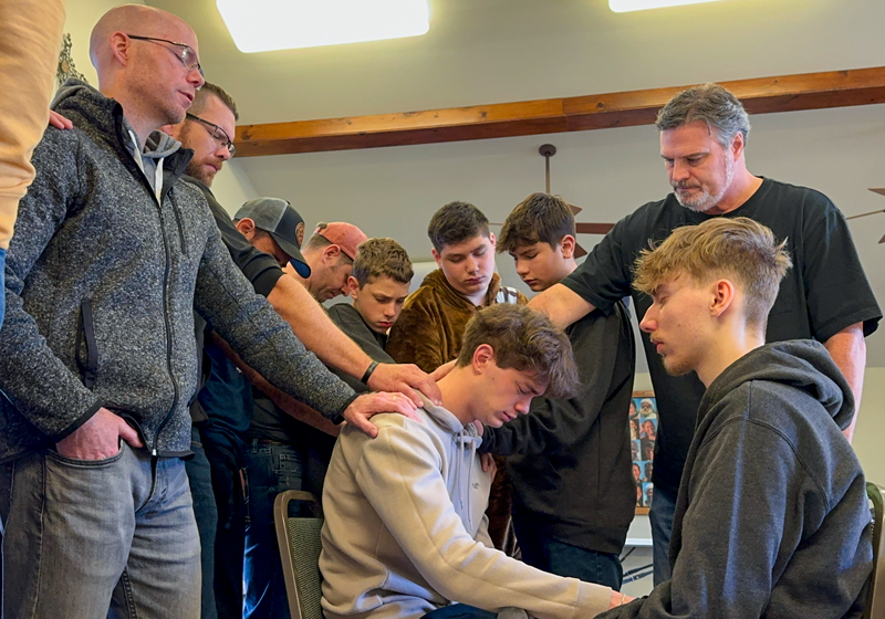 Men praying together at an Elevate retreat
